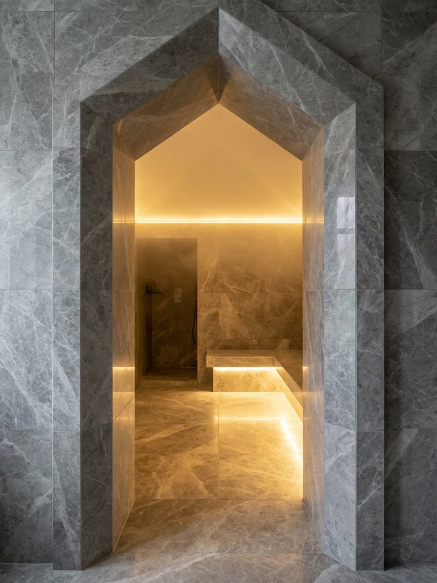 Faceted grey marble archway looking into the lit steam room