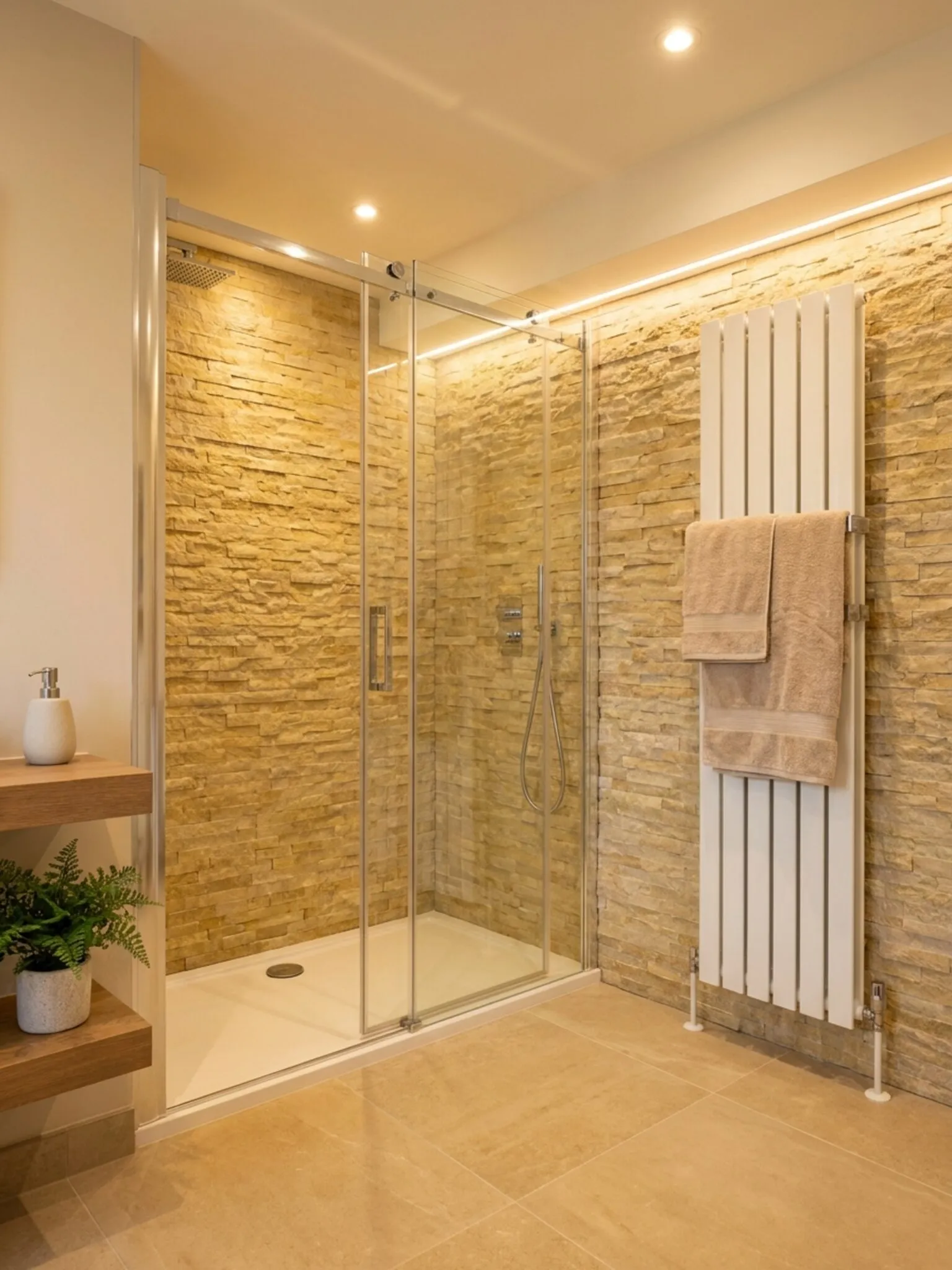 Frameless sliding shower enclosure and white designer towel radiator