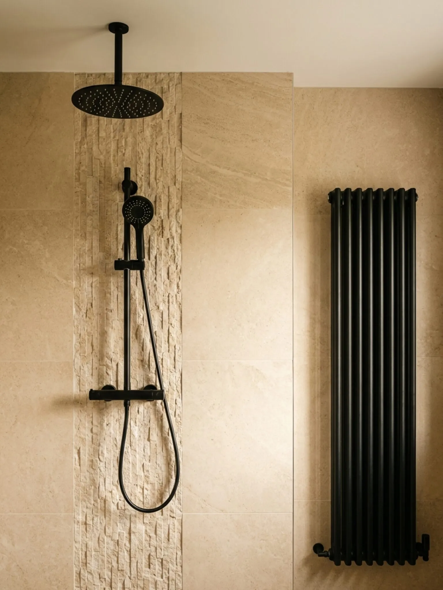 Shower wall with matt black rainhead and tall black radiator