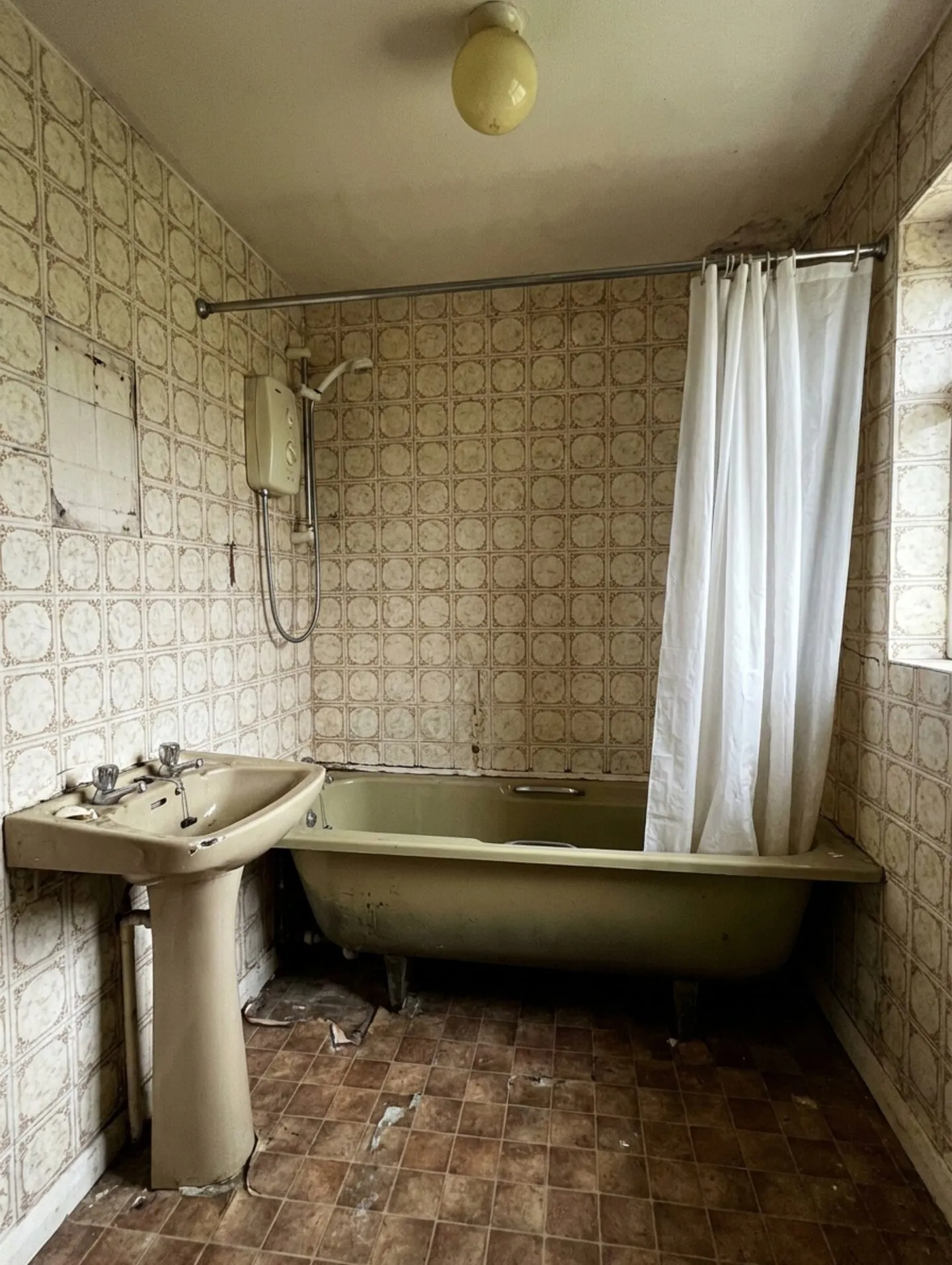 The same bathroom before renovation — stripped back to bare plaster walls